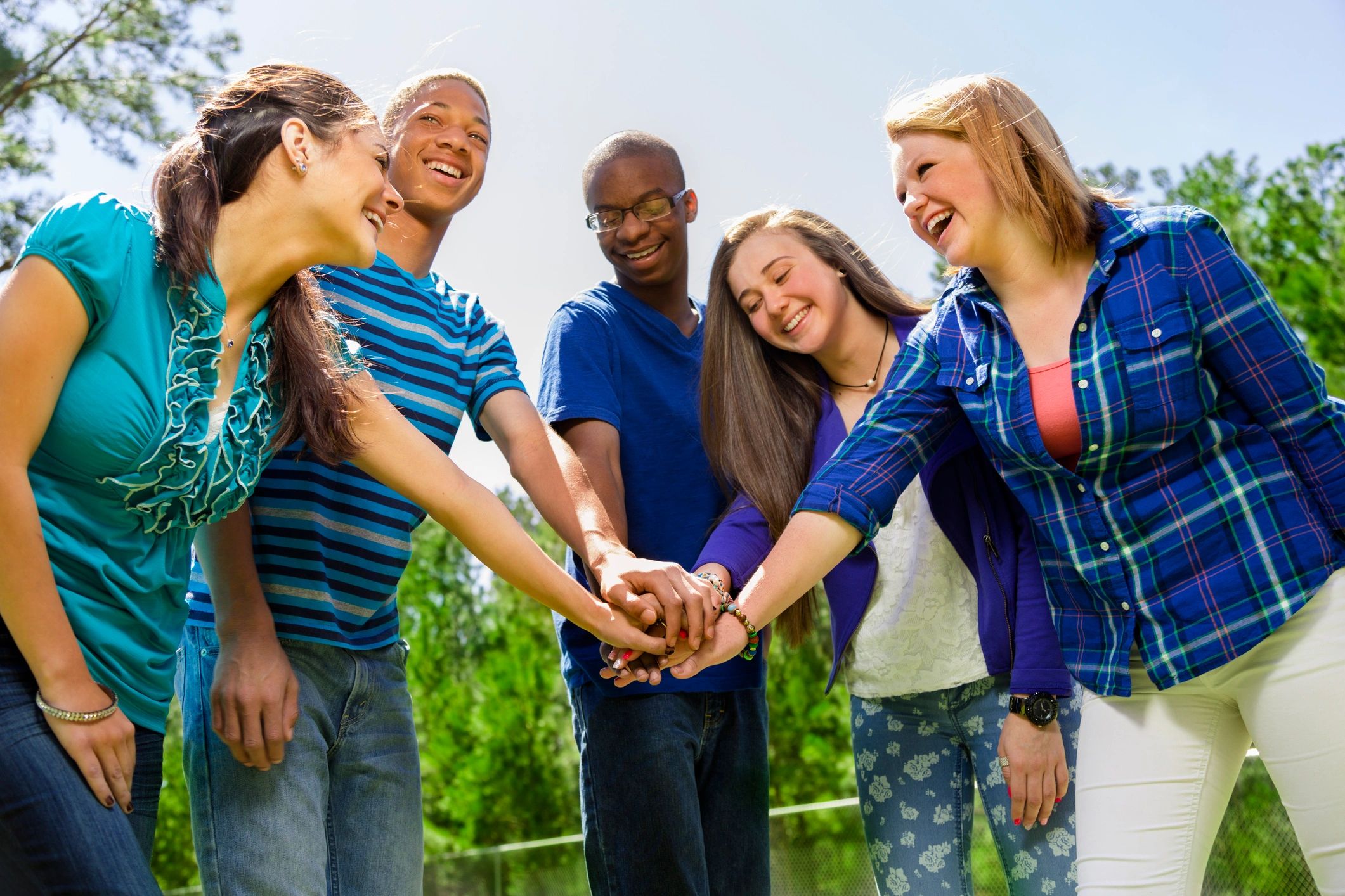 Teens showing unity with hands together